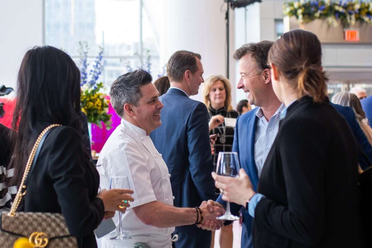 Two men shaking hands and smiling.
